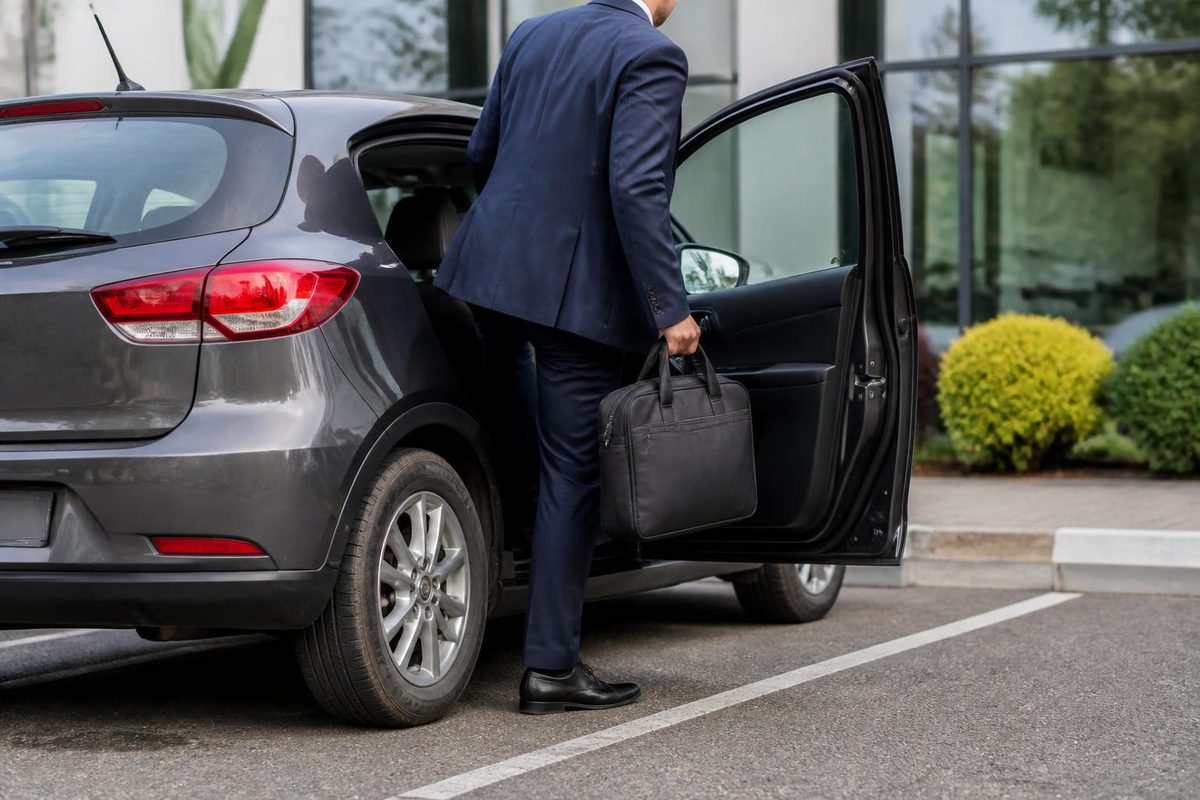 Employee stepping out of their own car at a client's office