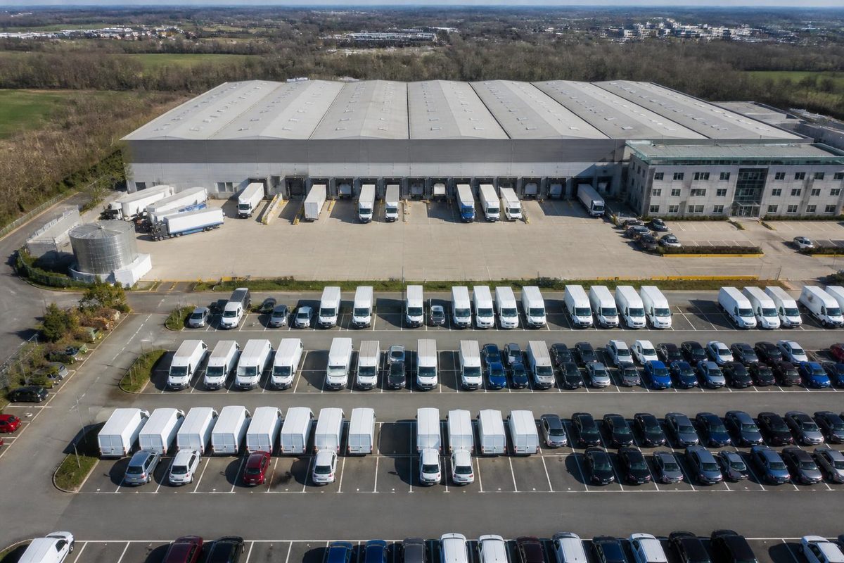 Aerial view of a large depot with rows of vans, cars and lorries